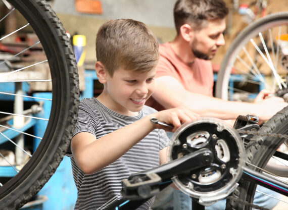 Enfant bricolant un vélo avec un adulte